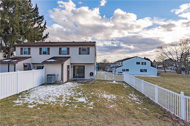 rear view of property with a yard and central air condition unit