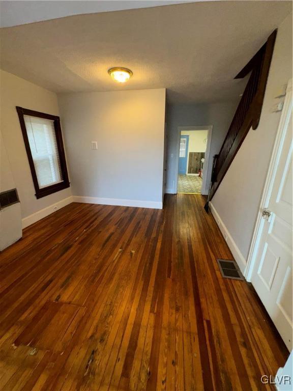 empty room with dark hardwood / wood-style flooring