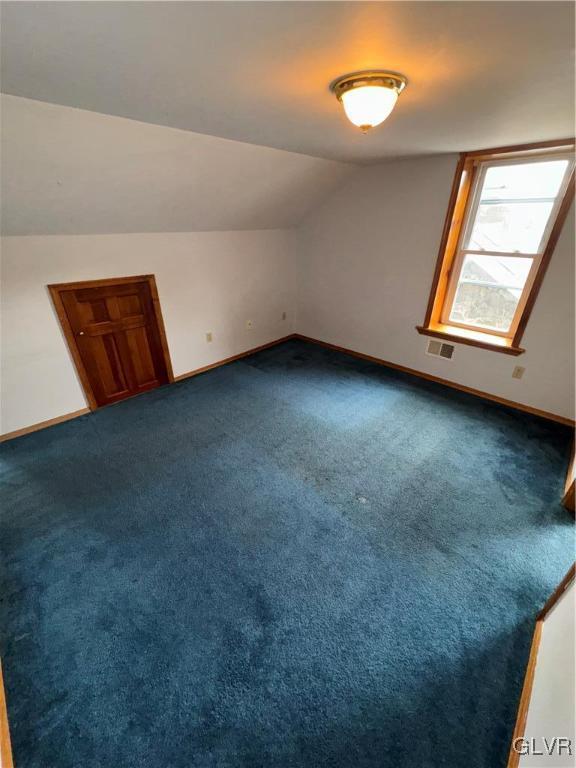 bonus room with lofted ceiling and carpet