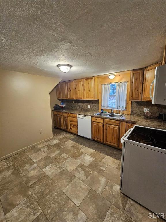 kitchen with sink, a textured ceiling, backsplash, and white appliances