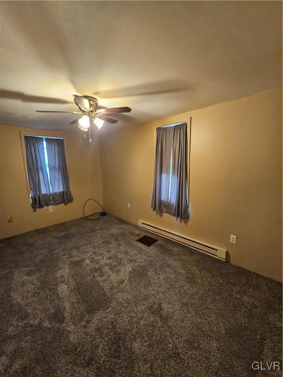 unfurnished room with carpet flooring, ceiling fan, and baseboard heating