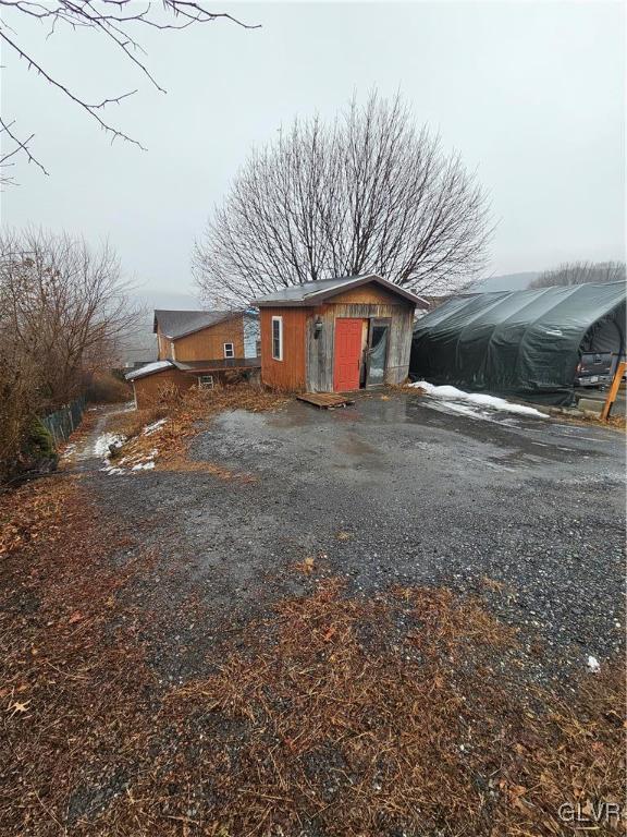 rear view of house with a storage shed