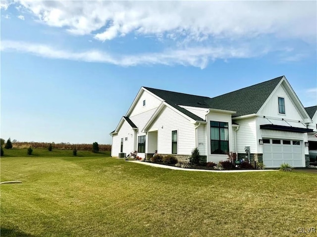 view of front of home featuring central AC, a garage, and a front yard