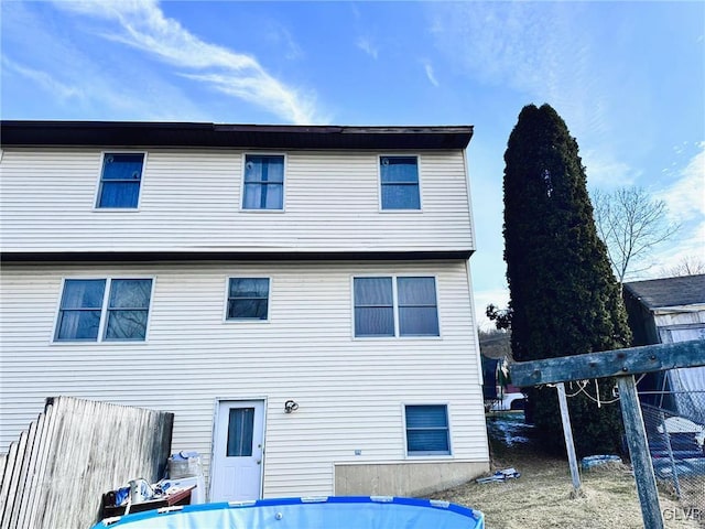 rear view of property featuring a pool