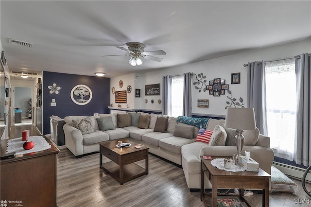 living room featuring wood-type flooring, ceiling fan, and a baseboard radiator