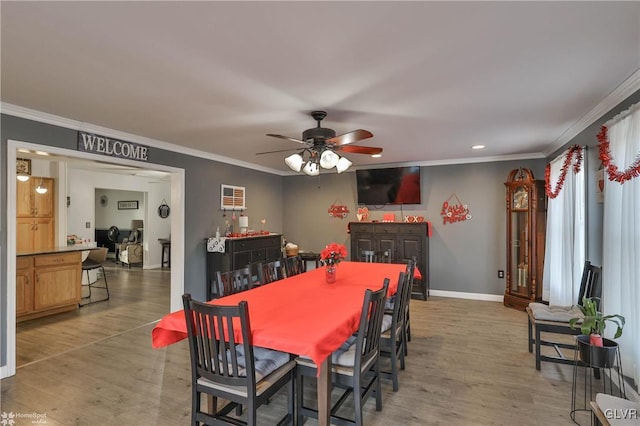 dining space with light hardwood / wood-style flooring and ornamental molding