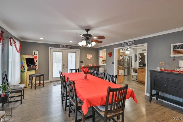 dining area featuring hardwood / wood-style flooring, ornamental molding, and french doors