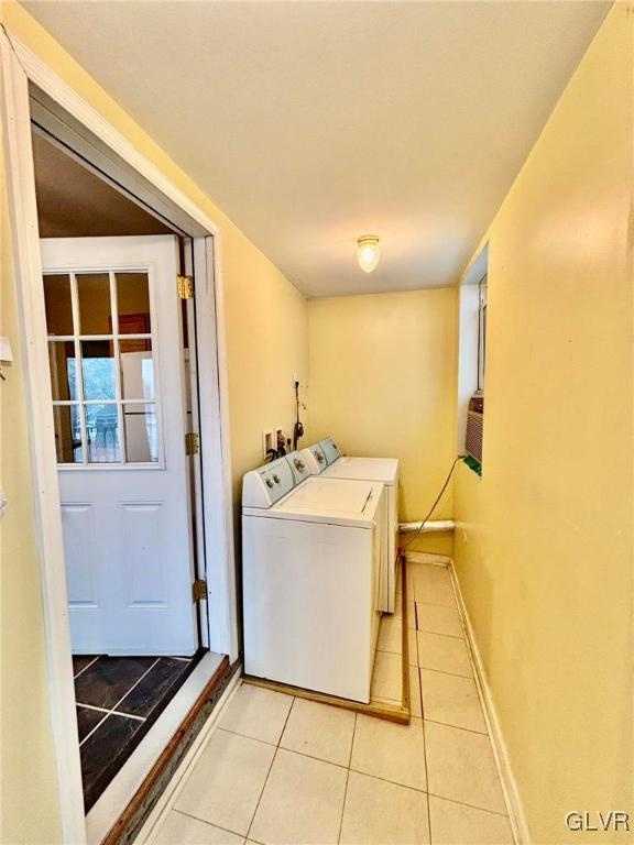 laundry room featuring washing machine and dryer and light tile patterned floors