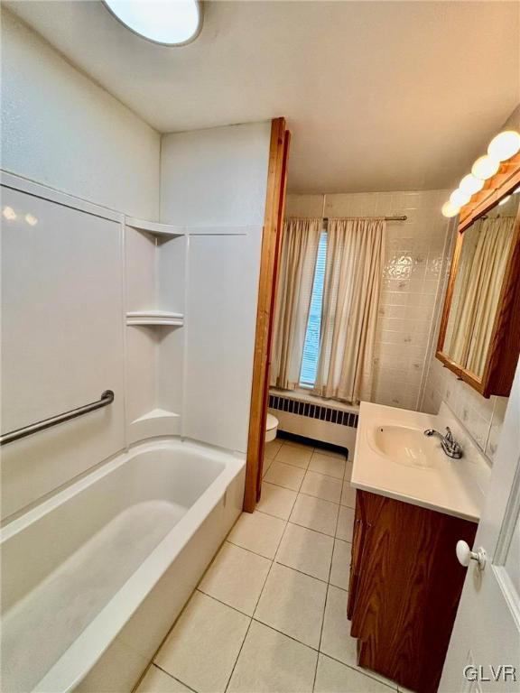 full bathroom featuring radiator,  shower combination, vanity, tile patterned floors, and toilet