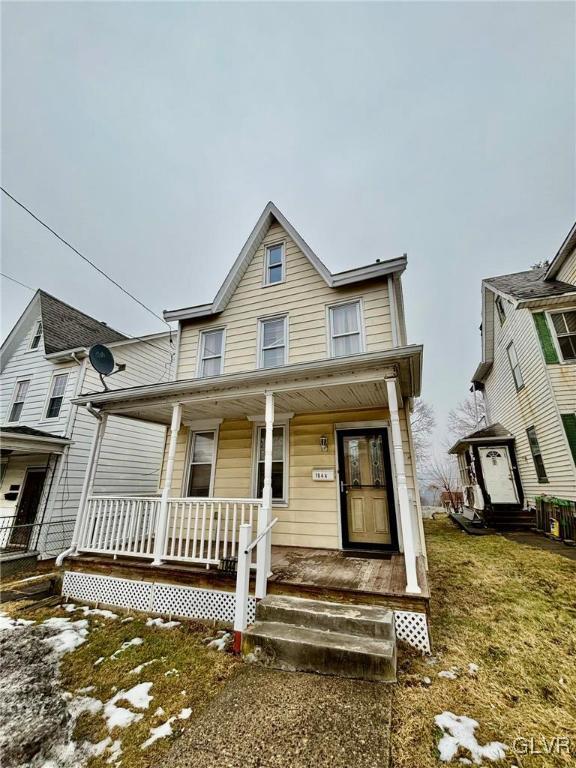 view of front of property with covered porch and a front yard