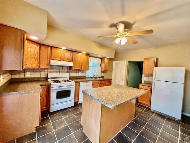 kitchen with sink, a kitchen island, dark tile patterned floors, white appliances, and decorative backsplash