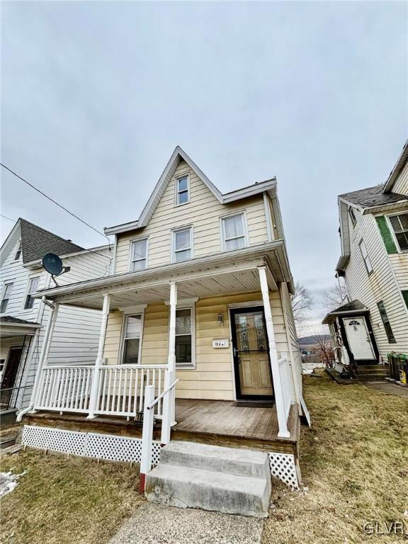 view of front facade with covered porch and a front yard