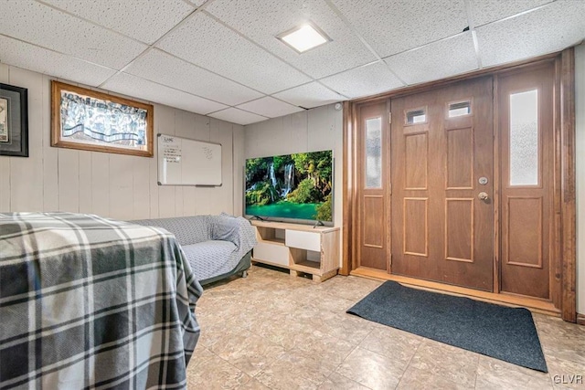 bedroom featuring a drop ceiling and multiple windows