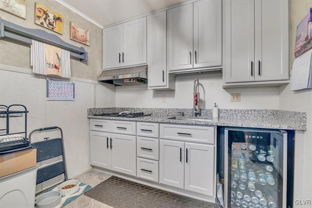 kitchen with sink, white cabinetry, light stone counters, beverage cooler, and stainless steel gas stovetop