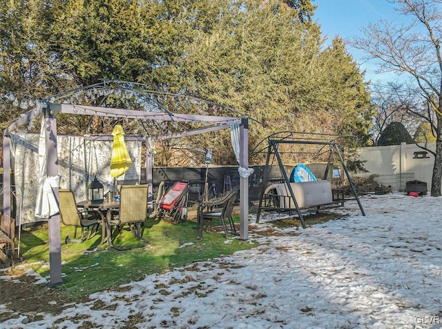 yard covered in snow featuring a playground