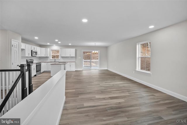 unfurnished living room featuring a chandelier and light hardwood / wood-style floors