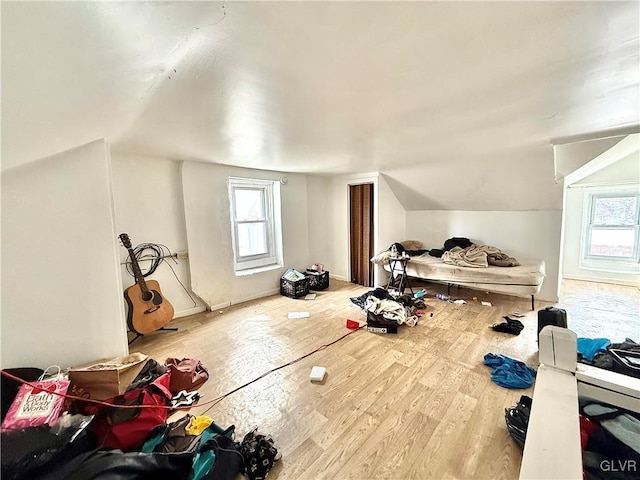 bonus room with hardwood / wood-style flooring and vaulted ceiling