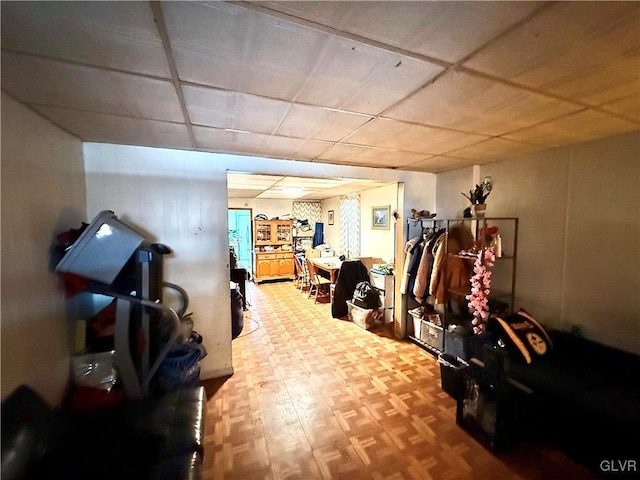 interior space with a paneled ceiling and parquet floors