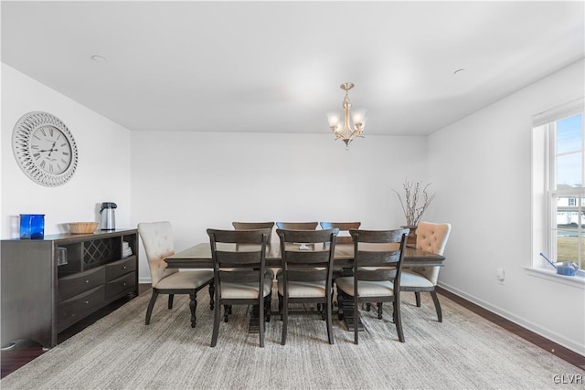 dining room with hardwood / wood-style flooring and a chandelier