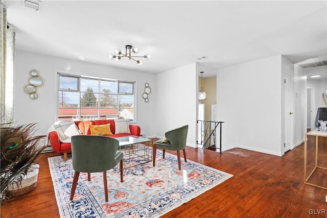 living room with dark wood-type flooring and a chandelier