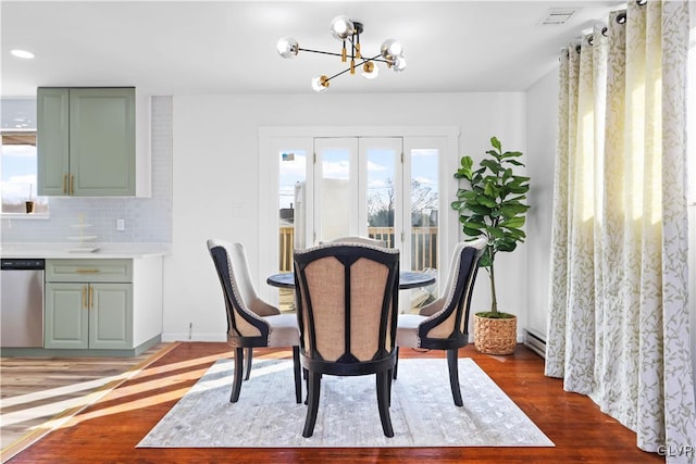 dining area featuring a notable chandelier, a baseboard radiator, and dark hardwood / wood-style floors