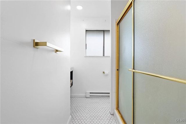 bathroom featuring tile patterned floors, a shower with door, and baseboard heating