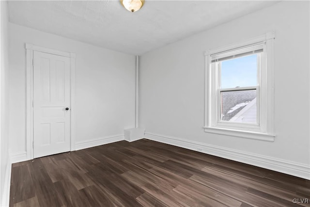 spare room featuring dark wood-type flooring