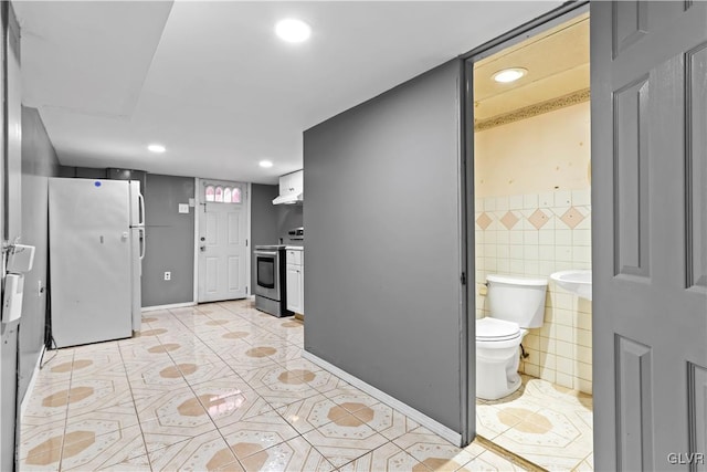 kitchen with white cabinetry, tile walls, white refrigerator, ventilation hood, and stainless steel electric stove