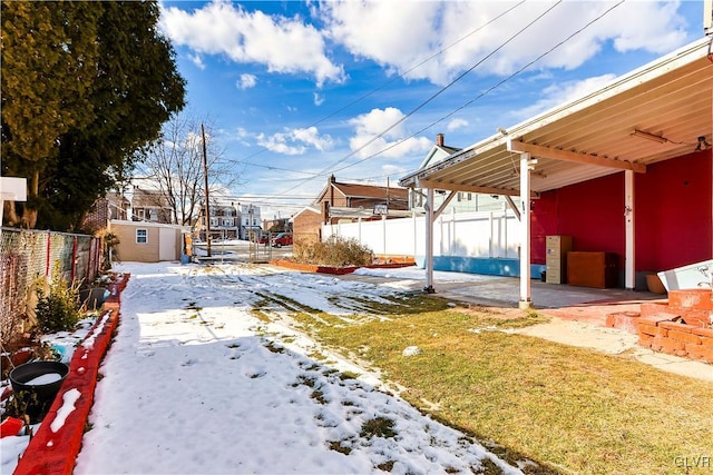 yard covered in snow featuring a storage unit