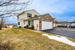 view of home's exterior with a garage and a lawn