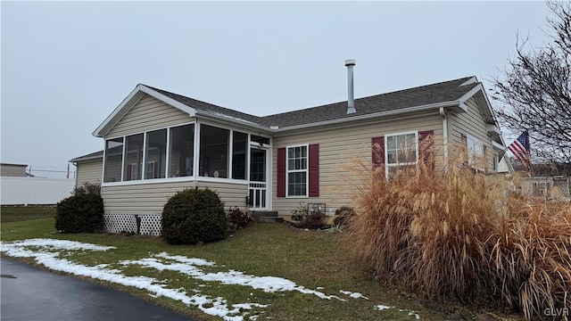 exterior space featuring a sunroom and a lawn