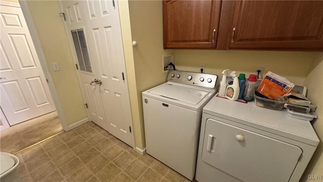 washroom featuring cabinets and washing machine and clothes dryer