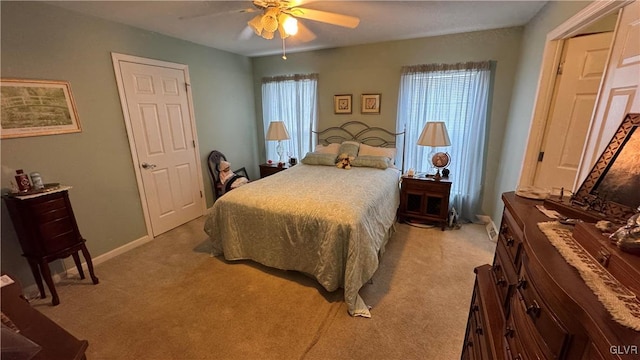 carpeted bedroom with ceiling fan and multiple windows