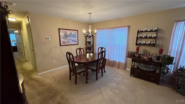 carpeted dining area featuring a chandelier