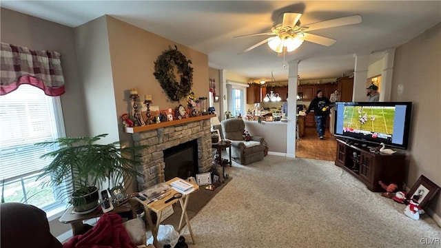 living room with ceiling fan, light colored carpet, and a fireplace