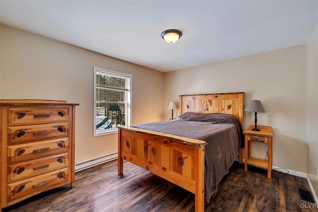 bedroom featuring a baseboard heating unit and dark wood-type flooring