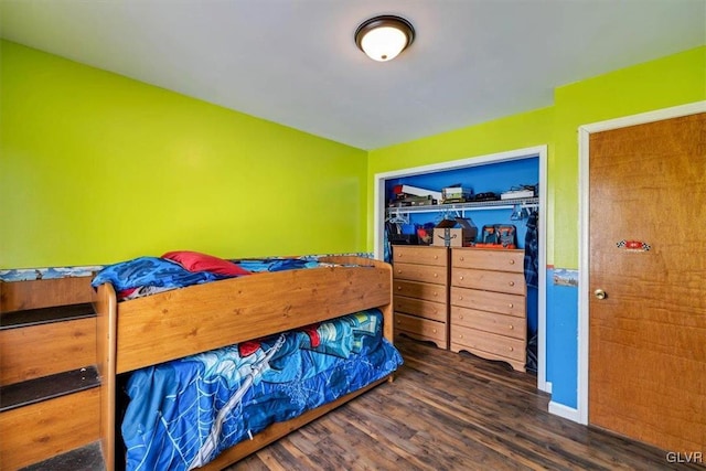 bedroom with dark hardwood / wood-style flooring and a closet