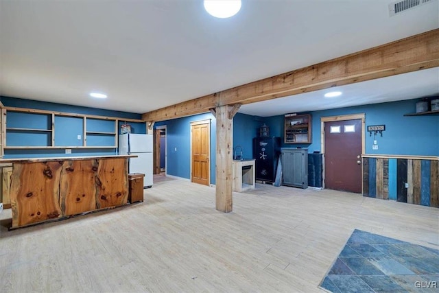 basement featuring white fridge and light hardwood / wood-style flooring