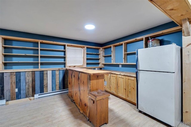 kitchen with white refrigerator, a baseboard radiator, light hardwood / wood-style floors, and butcher block countertops