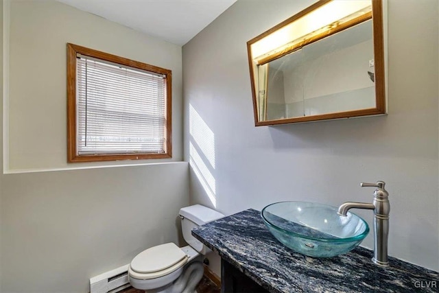 bathroom featuring vanity, a baseboard heating unit, and toilet