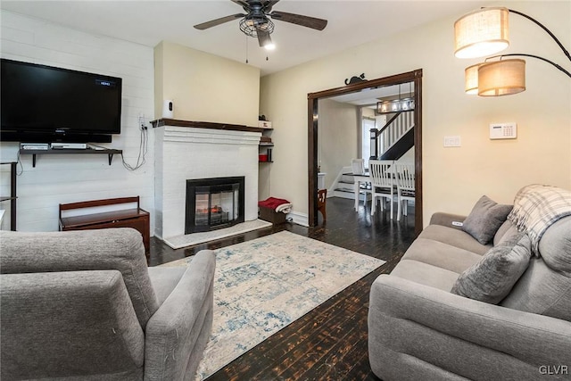 living room featuring ceiling fan and dark hardwood / wood-style flooring