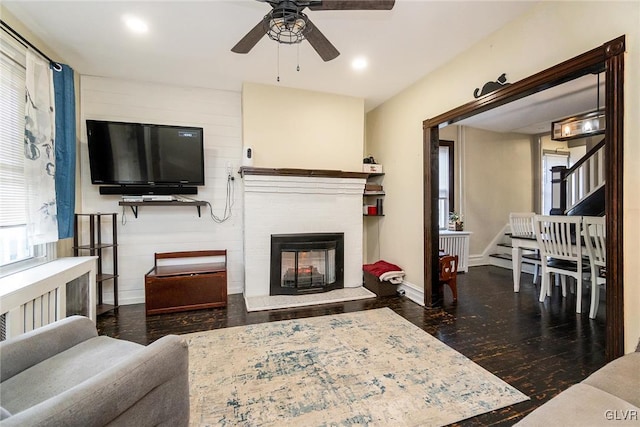 living room with ceiling fan and dark hardwood / wood-style floors