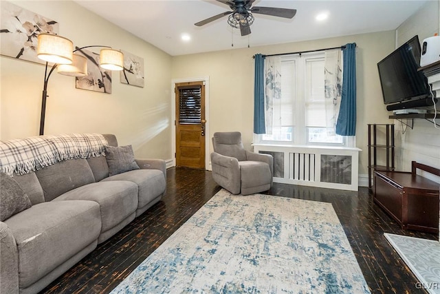 living room featuring radiator heating unit, dark wood-type flooring, and ceiling fan