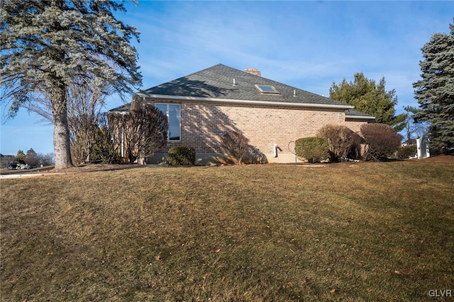 view of side of home with a lawn