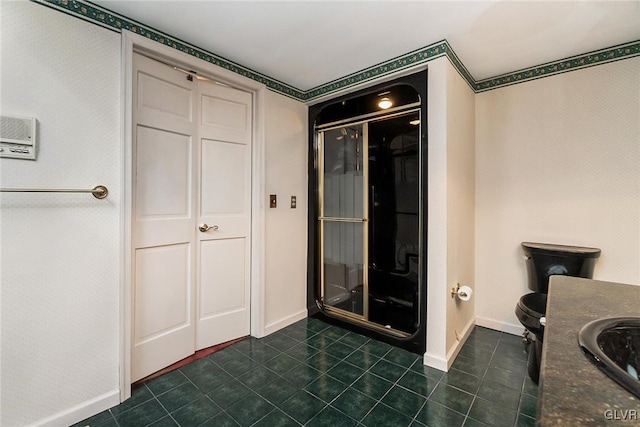 bathroom with vanity, a shower with shower door, tile patterned floors, and toilet