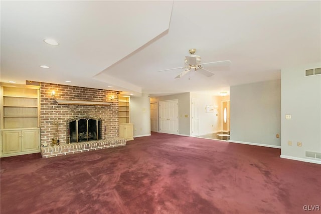 unfurnished living room featuring ceiling fan, carpet, a fireplace, and built in shelves