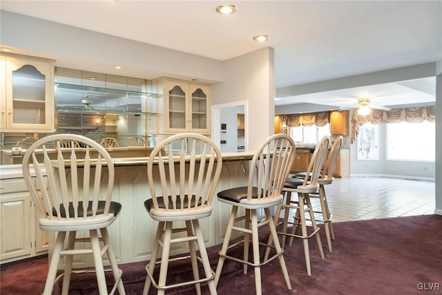 kitchen with cream cabinetry, a breakfast bar, and dark tile patterned floors