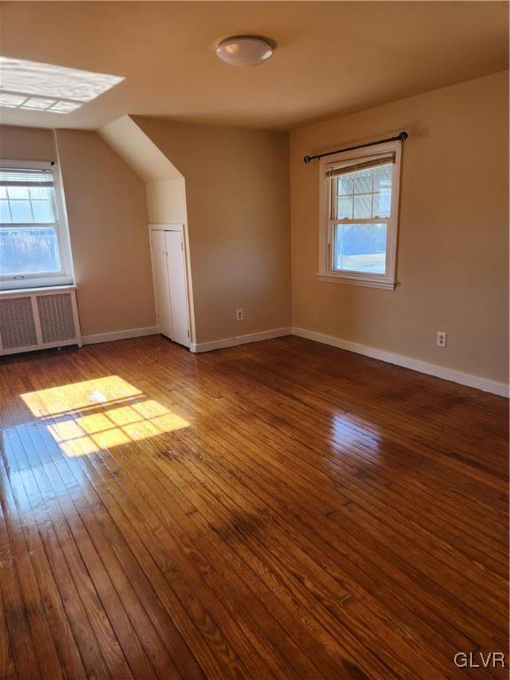 interior space with lofted ceiling, wood-type flooring, and radiator