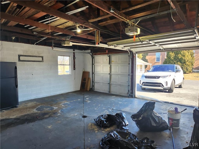 garage with black refrigerator and a garage door opener