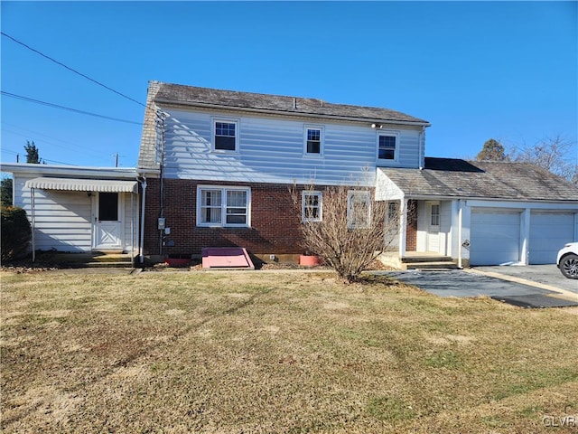 rear view of house featuring a garage and a yard